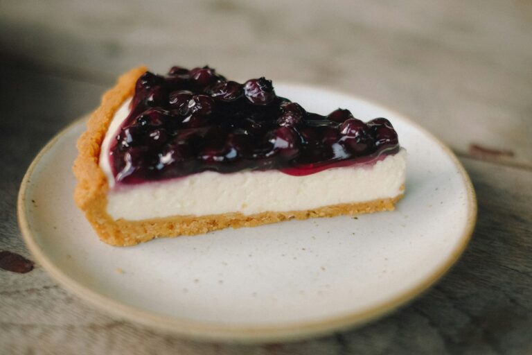 A slice of cheesecake with a glossy blueberry topping
