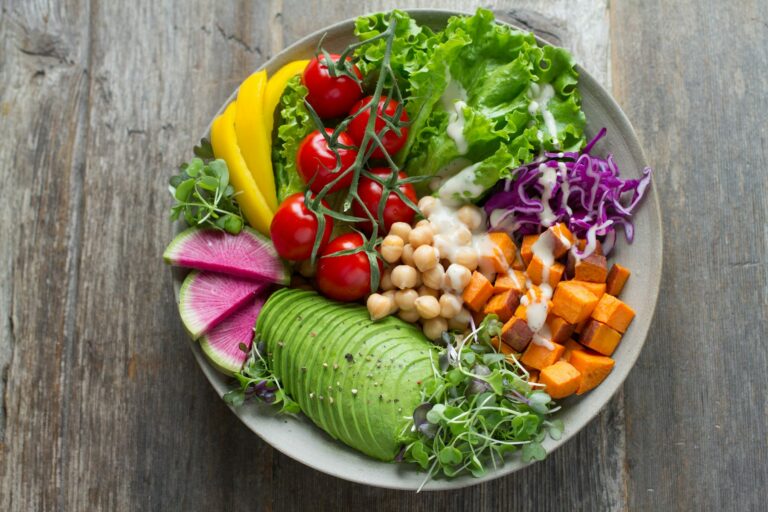 A bowl of avocado, chickpeas, cherry tomatoes, red cabbage and greens