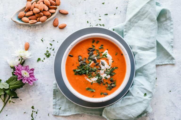A bowl of smooth roasted tomato soup garnished with herbs